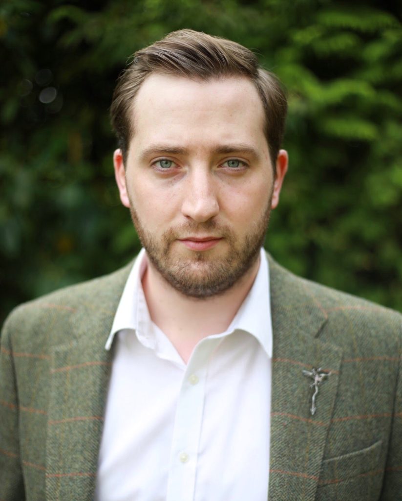 A photo of Michael from the shoulders up, wearing a green jacket