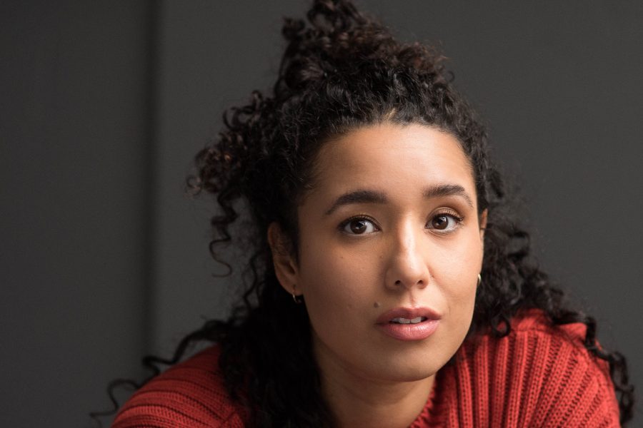 A photo of Josie White looking at the camera. Her hair is tied back and she is wearing a copper coloured cardigan.